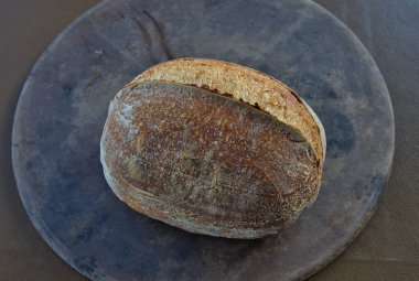 Artisan Sourdough Bread loaf on a pizza stone direct from the oven