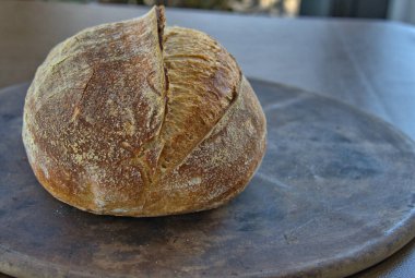 Artisan Sourdough Bread loaf on a pizza stone direct from the oven