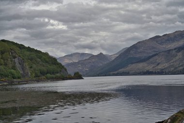Dağları ve bulutlu gökyüzü olan renkli Skye Gölü Adası