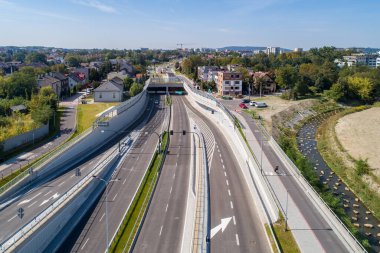 Polonya 'nın Krakow kentindeki yeni Trasa Lagiewnicka otoyolu. Tünelleri, kayma yolları, bisiklet yolları ve yayalar için kaldırımları var. Taşlarla süslenmiş Wilga nehri.