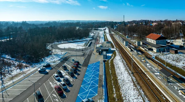 P+R. Park and Ride big parking lot, with facilities for disabled and a small railway station in Swoszowice district in Krakow, Poland, for fast city train to the town center. Aerial view in winter