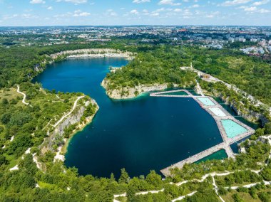 Zakrzowek, Krakow, Poland. Swimming and paddling pools and sunbathing  platforms on Zakrzowek lake with steep cliffs in place of former flooded limestone quarry. New public recreational place. Aerial clipart