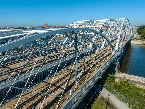 波兰克拉科夫维斯瓦河上有四条铁轨的三重弧形铁桥 背景是个老城区空中无人驾驶飞机视图 图库图片