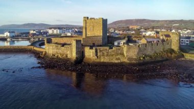 Ortaçağ Norman Kalesi ve Carrickfergus Limanı. Gün doğumunda Belfast yakınlarında. Hava 4K Marina, Dalgakıran ve Kasaba 'nın görüntülerini yayınlıyor.