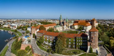 Polonya 'nın Krakow kentindeki Royal Wawel Gotik Katedrali, Rönesans Sigismund Şapeli, altın kubbe, yürüyen insanlar ve yıkılmış eski bir binanın temelleri ve iki kilisenin çimenliği ile. Hava görünümü