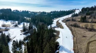 Polonya 'daki Bialka Tatrzanska kayak merkezinde kayak pistleri, teleferikler, kayakçılar ve snowboardcular. Gün batımında hava 4K yeniden değerlendirme videosu