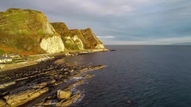 Atlantik kıyısında kayalıklar, Kuzey İrlanda. Garron Noktası. Jeolojik oluşum, park yeri ve Causeway Sahil Yolu. Avrupa 'nın en manzaralı kıyı yollarından biri. Hava görüntüsü. Gün doğumu ışığı. Kış