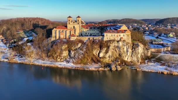 波兰克拉科夫附近的提尼茨在陡峭的岩石悬崖上的本笃会修道院 修道院和教堂及其在维斯瓦河中的水倒影 在夕阳西下的冬季空中接近录像 — 图库视频影像