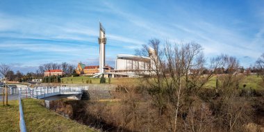 Krakow, Polonya - 10 Şubat 2024: Saint Fautsine Mabedi ve postmodern İlahi Merhamet Kilisesi. Wilga nehri üzerinde park ve köprü. Kış manzarası