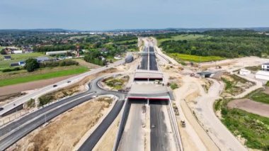 Krakow çevresindeki otoyolun kuzey kısmı yapım aşamasında. Zielonki kavşağında trafik çemberi, viyadük ve rampa olan S52 parçası. Ağustos 2024 'te eyalet. Hava 4K yaklaşıyor.