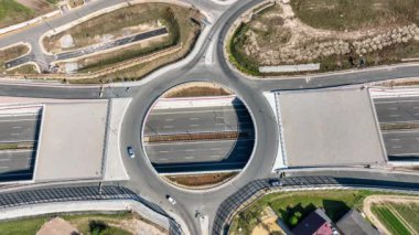 Krakow, Polonya. Batowice karayolu kavşağı S53 'te yapım aşamasında. Cracow çevresindeki otoyolun bir parçası. İçinde delik olan trafik çemberi, viyadikler, tüneller ve rampalar. Eylül 2024. Hava görünümü