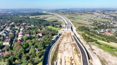 Krakow, Polonya. Wegrzce karayolu kavşağı S53 'te yapım aşamasında, Cracow civarındaki otoyol halkasının bir parçası. İçinde delik olan trafik çemberi, viyadikler, tüneller ve rampalar. Eylül 2024. Hava görünümü