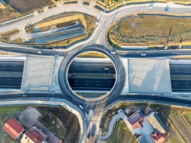 Krakow, Polonya. Yeni S52 otoyolunda Batowice karayolu kavşağı 23 Aralık 2024 'te açıldı. Cracow çevresindeki otobanın bir parçası. Trafik çemberi içinde bir delik ve rampalar var. Gün batımında yukarıdan hava görüntüsü