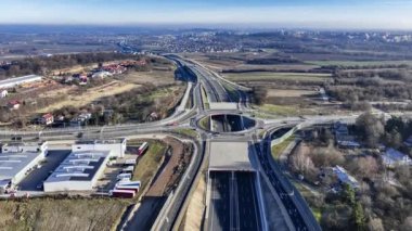 Krakow, Polonya. Krakow çevresindeki otoyolun bir parçası olan yeni S52 karayolu 23 Aralık 2024 'te açıldı. Yedinci karayolu ile kavşakta trafik çemberi içinde bir delik ve rampalar var. Hava 4K videosu