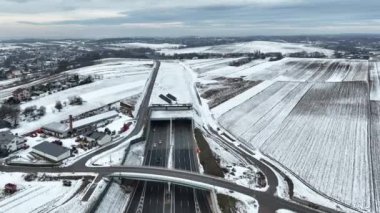 Polonya 'nın yeni çoklu şeritli otoyolu S52' de kışın karla kaplı Dziekanowice köyünde 23 Aralık 2024 'te bir tünel açıldı. Krakow çevresindeki otobanın bir parçası. Doğu yakasından havadan 4K videosu
