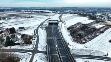 Dziekanowice köyünde kışın karla kaplı bir tünel. Polonya 'da yeni çoklu şeritli otoyol S52, Aralık 2024' te açıldı. Krakow 'un çevresindeki çevre yolunun bir parçası. Hava 4K batı yakasına doğru yaklaşıyor.