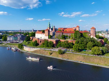 Polonya, Krakow. Wawel Katedrali ve Polonya devleti Royal Wawel kalesine sahip. Turist gemileri ve tekneleri, küçük limanları, bulvarları, parkları, yürüyen ve bisikletli insanları olan Vistula nehri. Boşluğu kopyala 