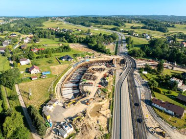 Polonya. Krzyszkowice köyündeki Zakopianka otoyolunda inşa halindeki tünelle yeni bir kavşak. Haziran 2025 'te eyalet. Hava aracı görünümü