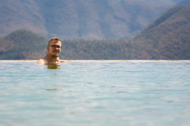 Beautiful landscape of natural infinity pool Hierve el Agua with young caucasian man relaxing, waterfalls Oaxaca, Mexico