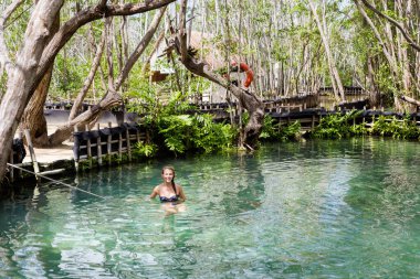 Güneşli bir günde El Corchito Ekolojik Rezerv, Progreso, Meksika 'da yüzen güzel beyaz kadın turist. Eko kavramı.