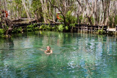 Güneşli bir günde El Corchito Ekolojik Rezerv, Progreso, Meksika 'da yüzen güzel beyaz kadın turist. Eko kavramı.