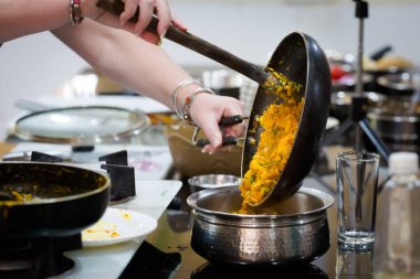 Traditional way of preparing indian food mushroom curry using gas pan. Picture of traditional India cuisine made of fresh ingredients taken during cooking class in Goa clipart