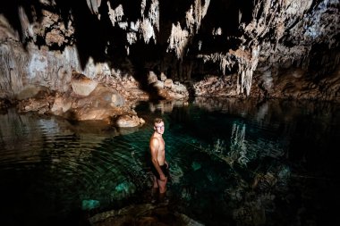 Young handsome man in Dzalbay, Sac Aua cenotes in Mexico, Valladolid area. Vivid landscape photo with lush green and crystal water