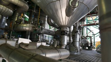 Boruları ve vanaları olan büyük bir sanayi fabrikası.