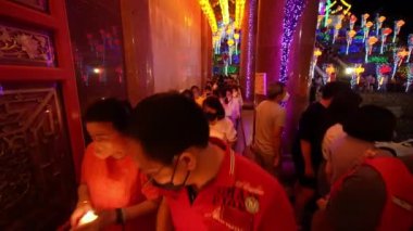 Ayer Itam, Penang, Malezya - 27 Şubat 2022: Budist fanatikler nilüfer mumunu tutarak Kek Lok Si tapınağında dolaşırlar