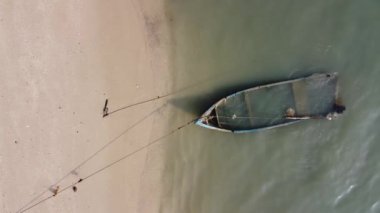 Deniz kıyısında tepeden aşağıya bakan bir tekne enkazı.