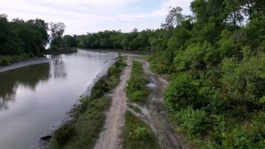 Nehrin kıyısındaki kuru toprak yolda yürü.