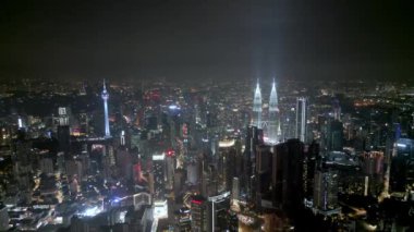Geceleri KL Kulesi ve KLCC 'ye doğru uçan hava aracı