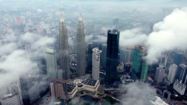 Bukit Bintang, Kuala Lumpur, Malaysia - Nov 13 2022: Drone shot move toward KLCC twin tower skyscraper in low foggy morning