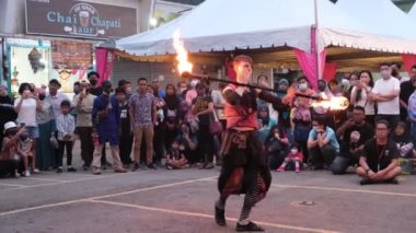 Butterworth, Penang, Malaysia - Dec 10 2022: A woman play fire stick in front of crowd at street