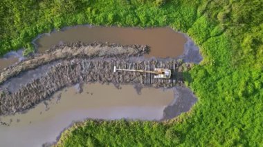 Aerial view look down excavator work on swamp wetland