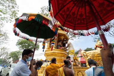 George Town, Penang, Malezya - 17 Ocak 2022: Hindu gönüllü gönüllü, altın at arabasının yanında şemsiye taşıyor