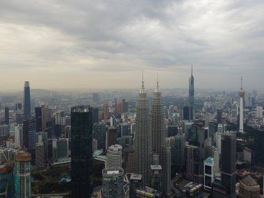 Bukit Bintang, Kuala Lumpur, Malezya - 25 Aralık 2022: Kuala Lumpur 'un ufuk çizgisinin havadan çekimleri, şehrin ikonik Petronas İkiz Kuleleri ve diğer gökdelenleri sergileniyor.