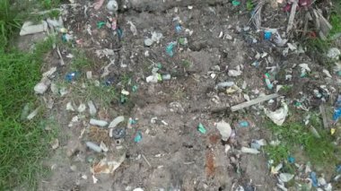 Çimlerle kaplı bir tarlanın tepesinde duran bir çöp yığını.