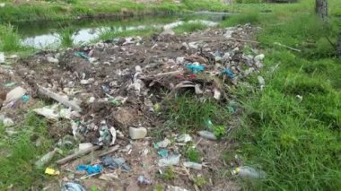 Kirli nehir kıyılarda birikmiş çöplerle