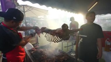 Bayan Lepas, Penang, Malezya - 25 Haziran 2023: Bir şahinin yetenekli elleri ızgarada koyun eti parçaları kesti