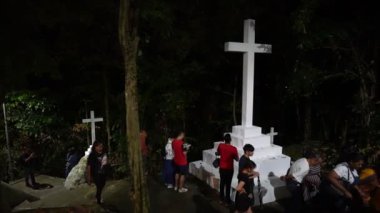 Bukit Mertajam, Penang, Malezya - 28 Haziran 2023: Hayranlar gece St. Anne Kilisesi 'nde beyaz bir haç etrafında dolaşır