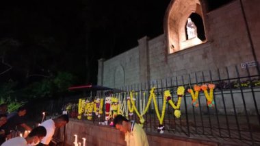 Bukit Mertajam, Penang, Malezya - 28 Haziran 2023: St. Anne ve Mary heykelinin önünde mum yakan ağır çekim yolcuları