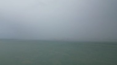 Denizde yağmurlu bir günde ilerleyen hava manzarası.