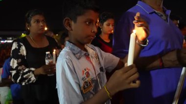 Bukit Mertajam, Penang, Malezya - 29 Haziran 2023: Aziz Anne ziyafeti sırasında elinde mum tutan genç bir çocuk