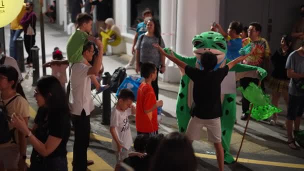 马来西亚槟城乔治城 2023年7月30日 慢动作的人与双阴青蛙吉祥物在街上跳舞 — 图库视频影像