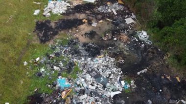 Yığınla çöp yemyeşil bir tarlada duruyor.