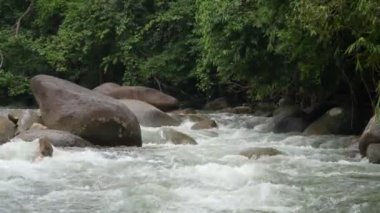 Sakin ve büyüleyici bir su manzarası kayaların sabit varlığının üzerine dökülüyor..