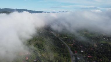 Yükseltilmiş bakış açısı, Baling 'deki bir köyün huzurlu atmosferini vurguluyor, Kedah alçak bulutların altında.
