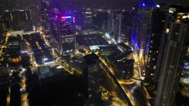 Bukit Bintang, Kuala Lumpur, Malezya - 02 Aralık 2023: Kuala Lumpur Sentral yakınlarındaki gökyüzünün karanlık tuvaline karşı aydınlanmış nöbetçiler gibi havadan yüksek binalar.