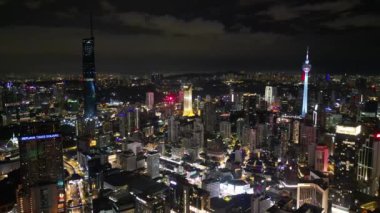 Bukit Bintang, Kuala Lumpur, Malezya - 20 Kasım 2023: Geceleri gökdelen işaretleri olan bir şehrin dinamik ve gelişen doğasını gösteren hava sahnesi